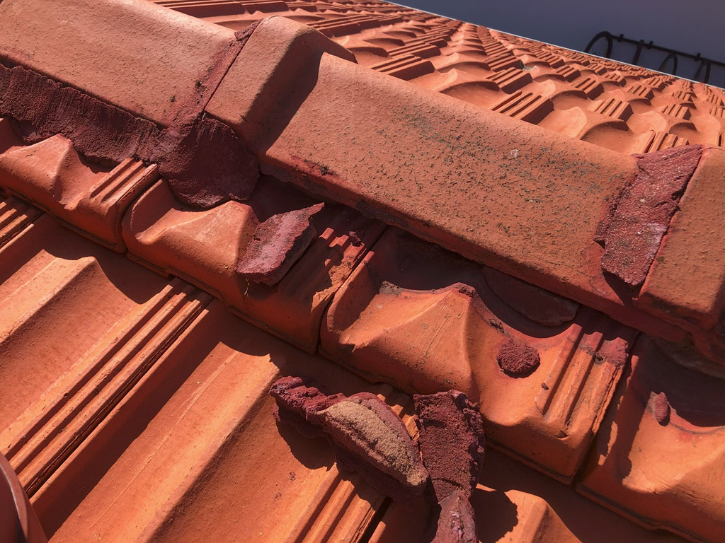 Damaged broken roof ridge tile pointing