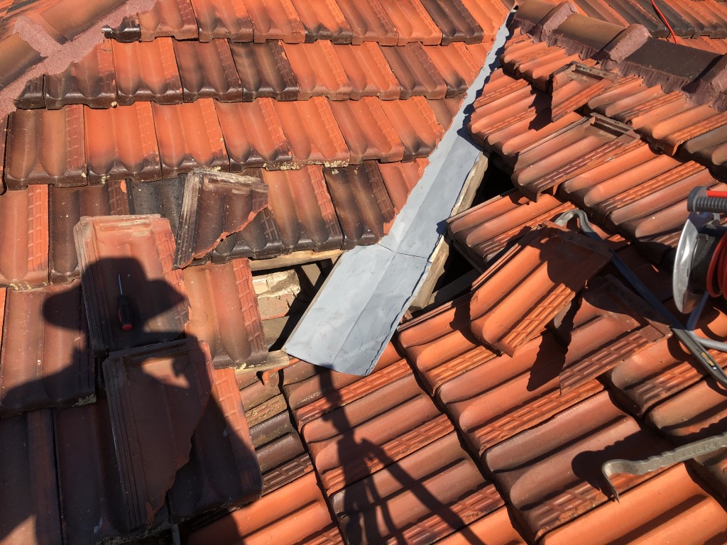 Partially removed tiles during valley gutter repair